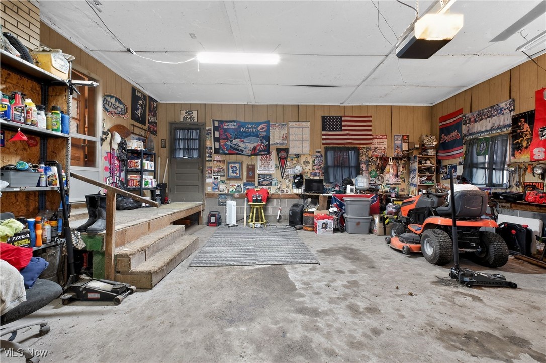 72631 Broadhead Road Kimbolton, OH 43749 - Photo 21 of 21 Garage with a garage door opener, wood walls, and a workshop area
