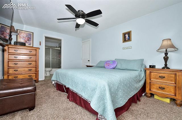 8515 Mohawk Road Colorado Springs, CO 80908 - Photo 12 of 28 Main level owners' suite has adjoining full bath, ceiling fan & 2 convenient entryways