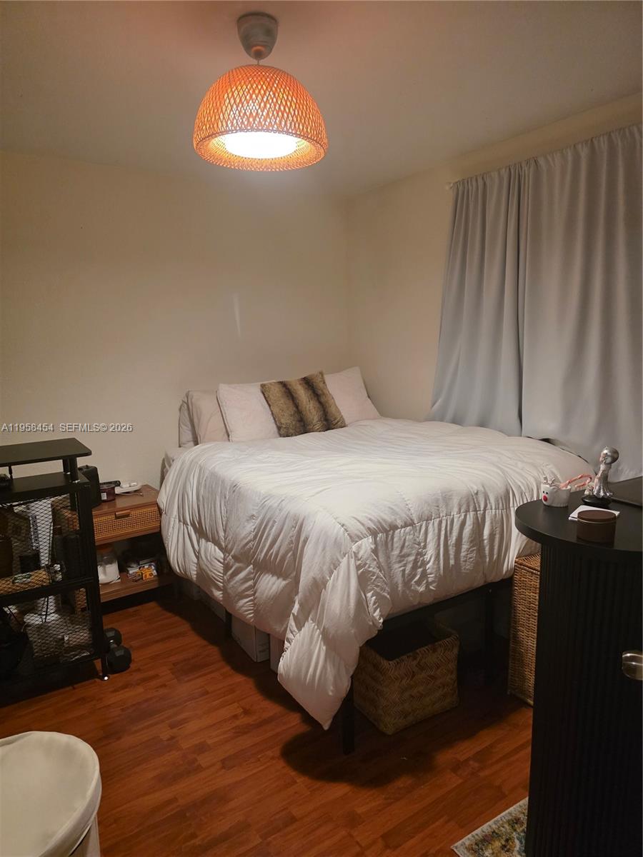 7701 West 36th Avenue, Unit 3 Hialeah, FL 33018 - Photo 12 of 28 a bedroom with a bed and a chandelier