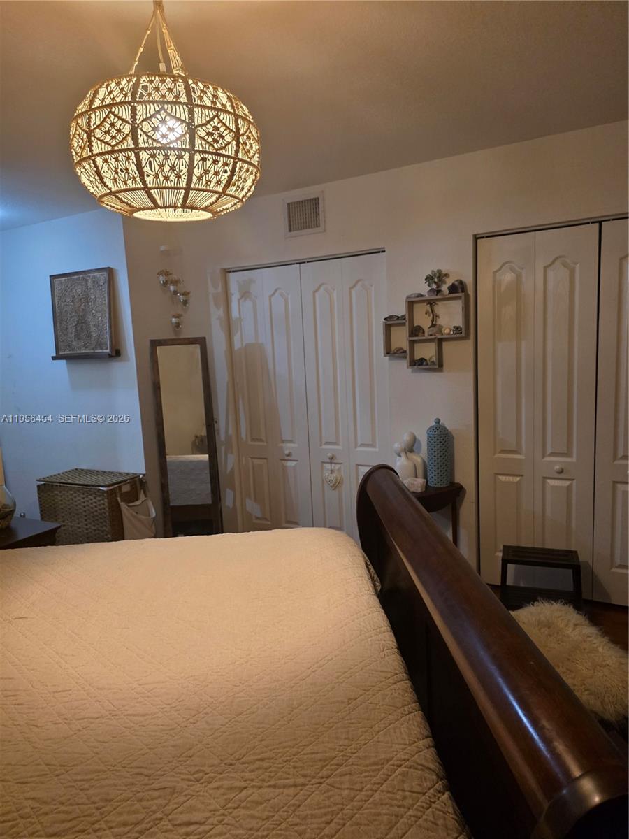 7701 West 36th Avenue, Unit 3 Hialeah, FL 33018 - Photo 15 of 28 a bedroom with a bed and a chandelier