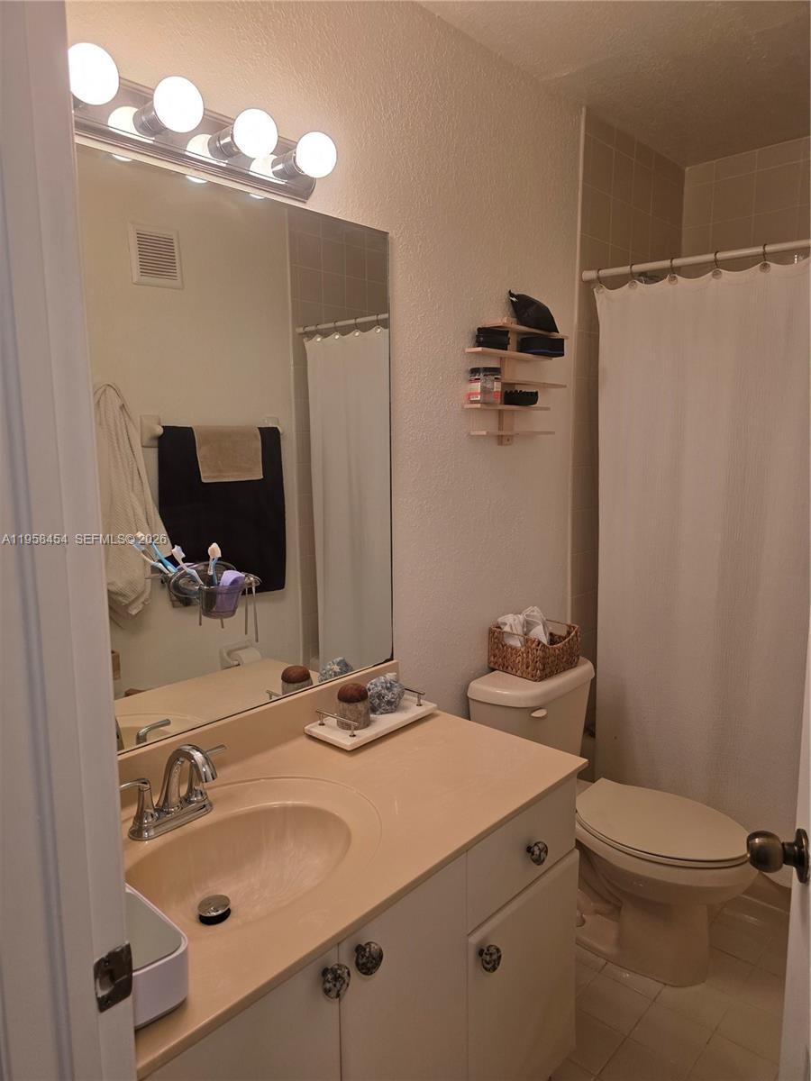7701 West 36th Avenue, Unit 3 Hialeah, FL 33018 - Photo 19 of 28 a bathroom with a sink vanity granite and toilet