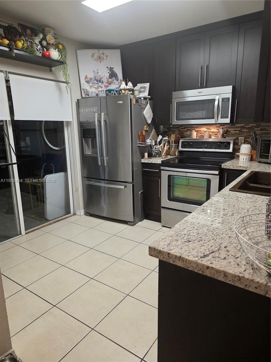 7701 West 36th Avenue, Unit 3 Hialeah, FL 33018 - Photo 7 of 28 a kitchen with stainless steel appliances granite countertop a refrigerator stove and microwave