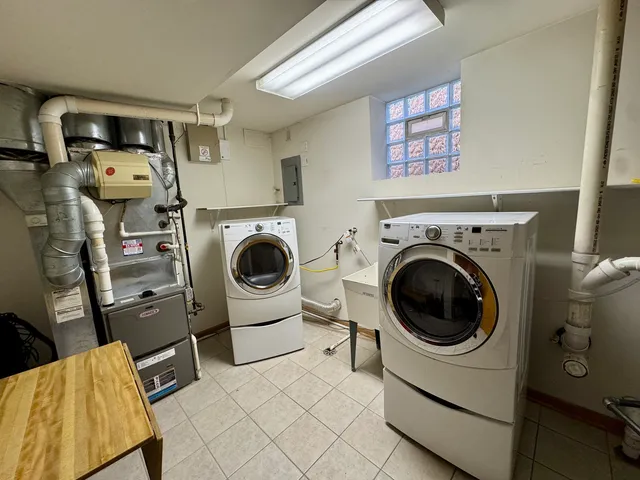 a utility room with dryer washer and a view of living room