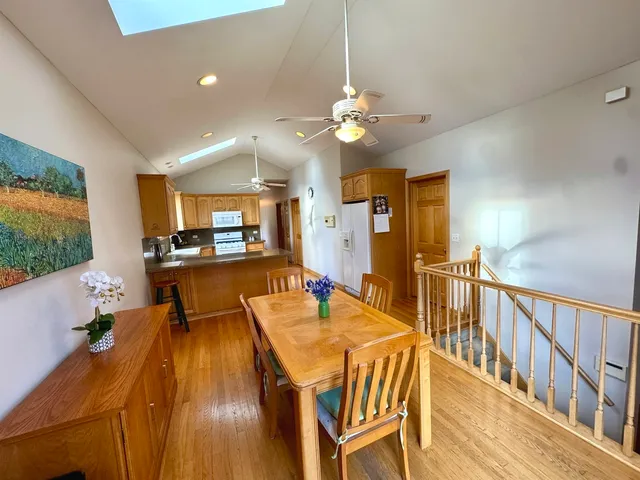 a dining room with stainless steel appliances kitchen island granite countertop a dining table chairs and a large window