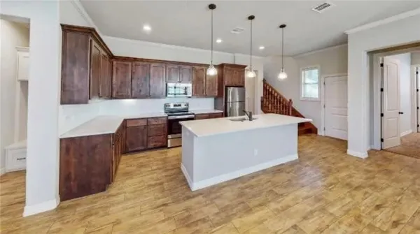 a large kitchen with kitchen island a sink stainless steel appliances and cabinets