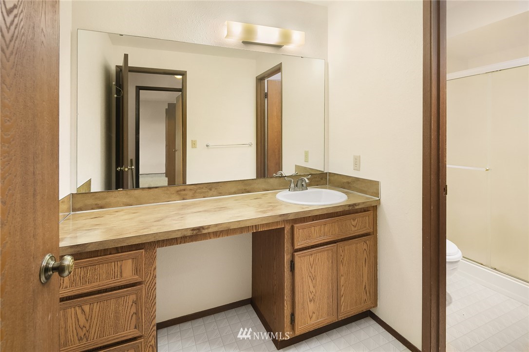1523 Eagle Ridge Drive South, Unit 1N Renton, WA 98055 - Photo 18 of 21 a bathroom with a granite countertop sink and a mirror