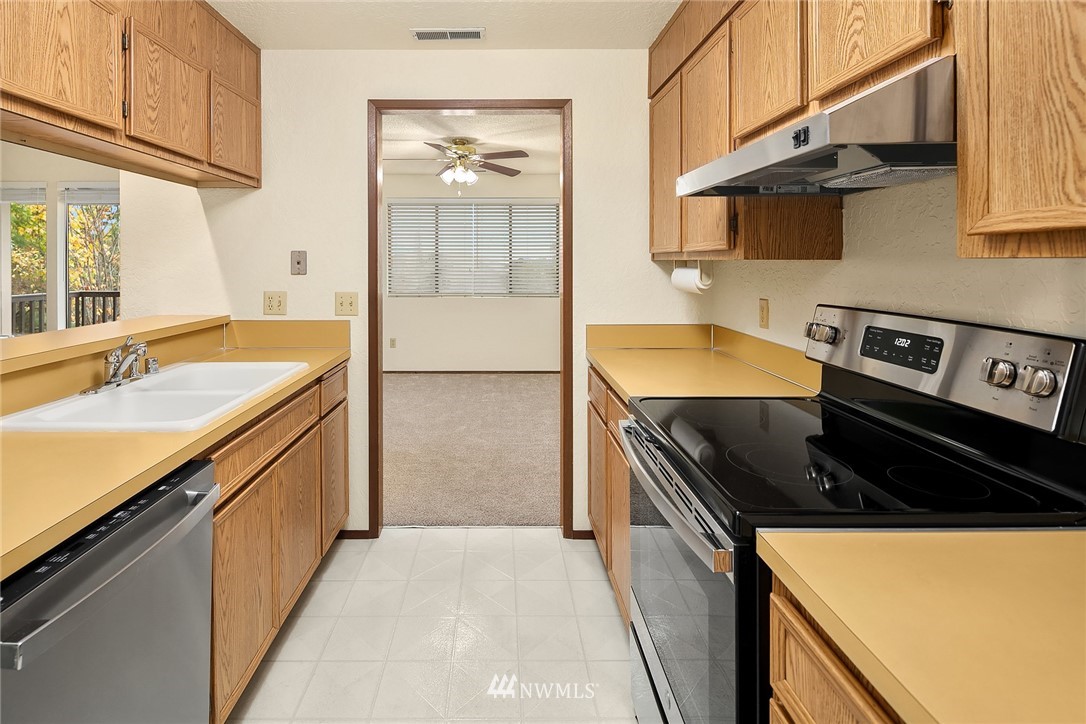 1523 Eagle Ridge Drive South, Unit 1N Renton, WA 98055 - Photo 3 of 21 a kitchen with stainless steel appliances granite countertop a sink stove and refrigerator