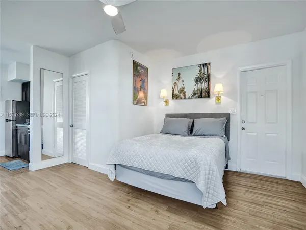 a spacious bedroom with a bed and a painting on the wall