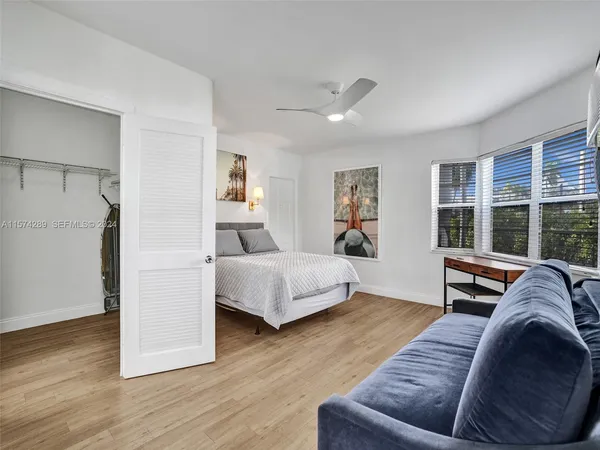a bedroom with a bed couch and a large window