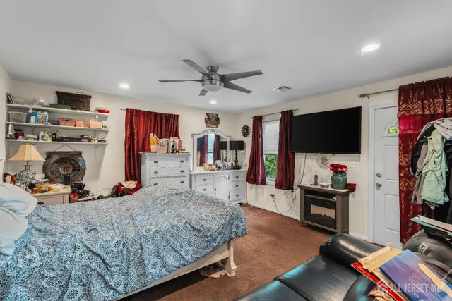 a bed room with a bed a television and a large window