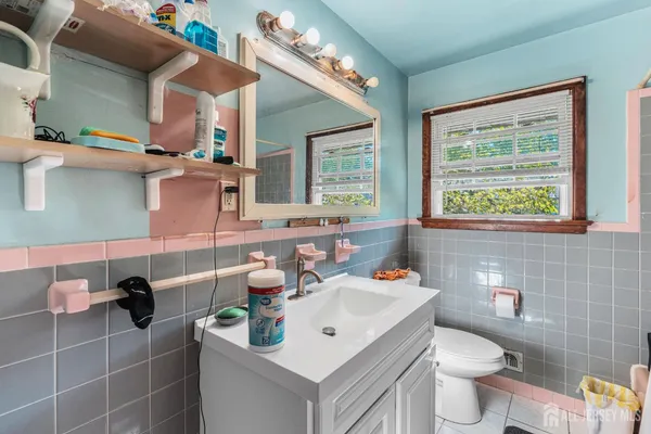 a bathroom with a sink mirror and toilet