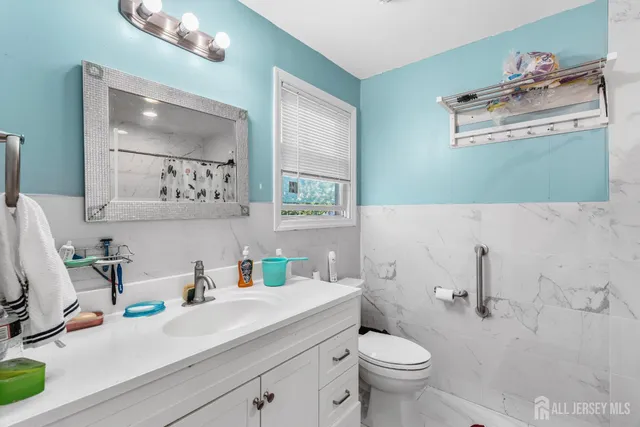 a bathroom with a sink vanity mirror and toilet