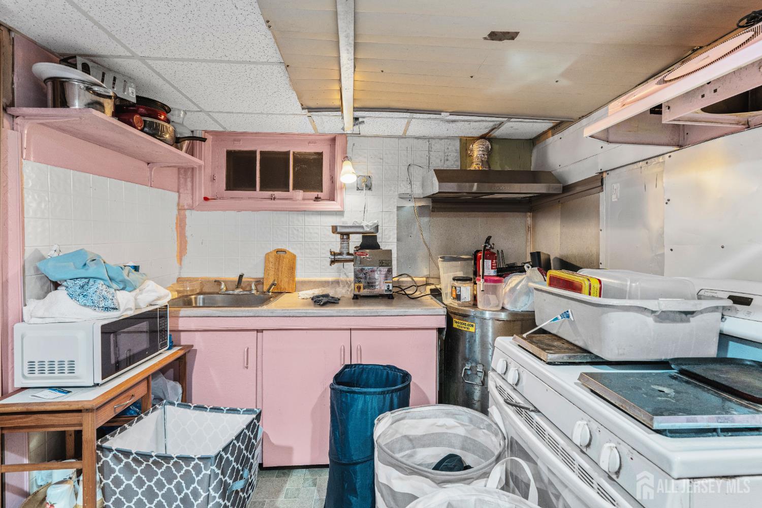 247 Adams Street Piscataway, NJ 08854 - Photo 33 of 49 a kitchen with granite countertop a stove and wooden cabinets