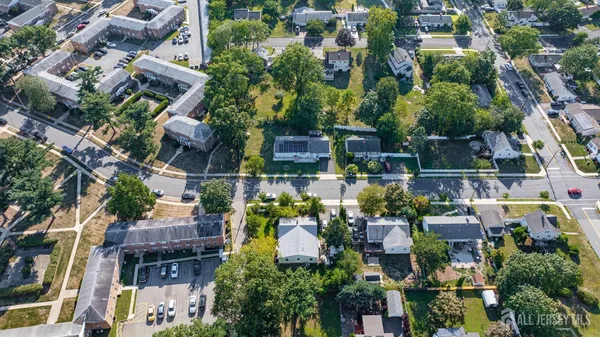 an aerial view of residential houses with outdoor space and trees
