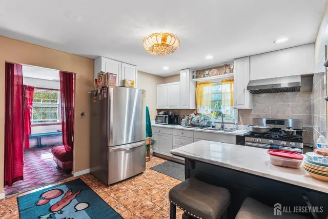 a kitchen with stainless steel appliances granite countertop a refrigerator and a stove top oven