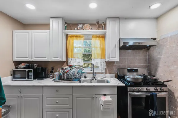 a kitchen with a sink stove top oven and cabinets