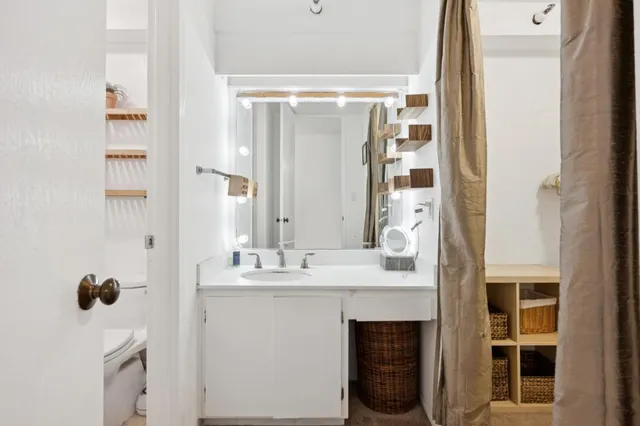 a bathroom with a sink vanity granite and a mirror