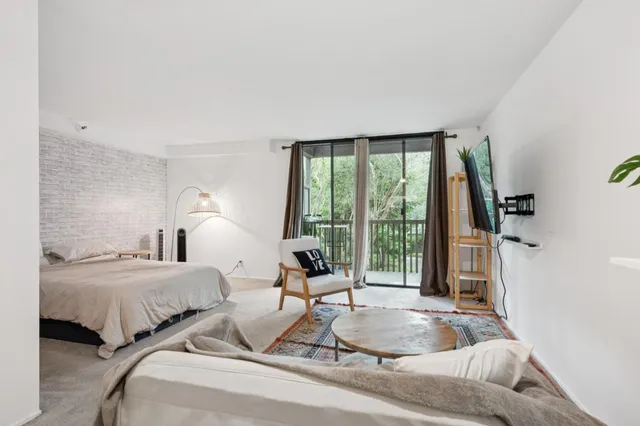 a bedroom with two beds and large windows