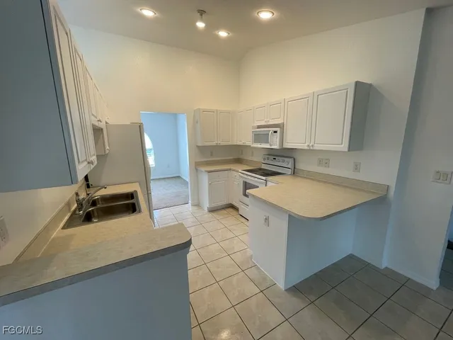 a kitchen with a sink refrigerator and cabinets