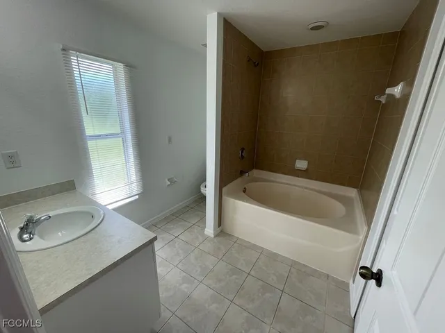 a bathroom with a tub sink and mirror