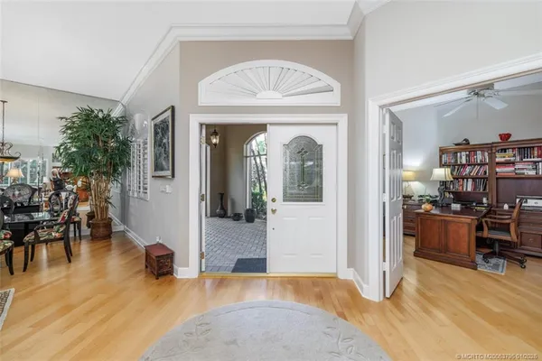 a view of a dining room and livingroom with furniture wooden floor a rug a potted plant and a chandelier