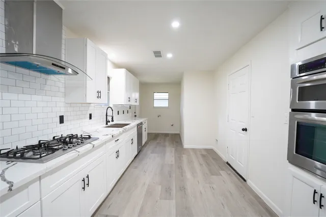 a kitchen with a sink stove and cabinets