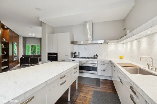 a large kitchen with stainless steel appliances kitchen island granite countertop a sink and cabinets