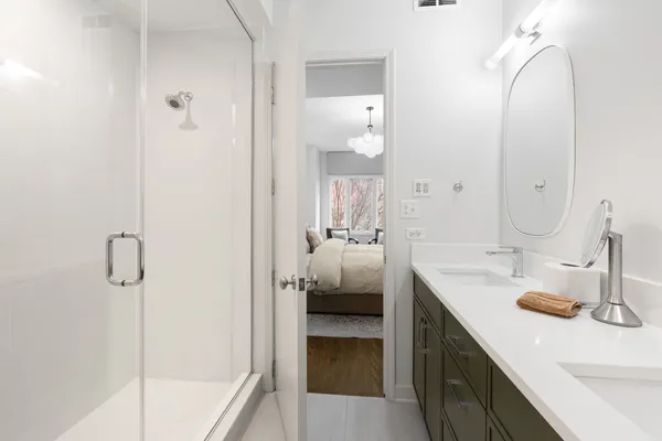 a en suite bathroom with a double vanity sink a mirror and shower
