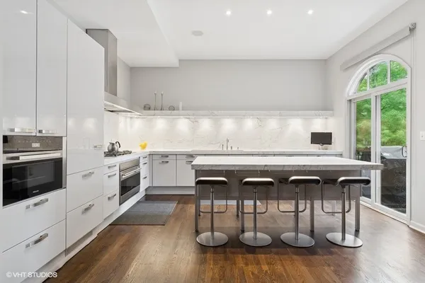 a kitchen with stainless steel appliances granite countertop a stove a sink and a refrigerator