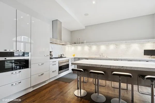 a kitchen with appliances cabinets and chair