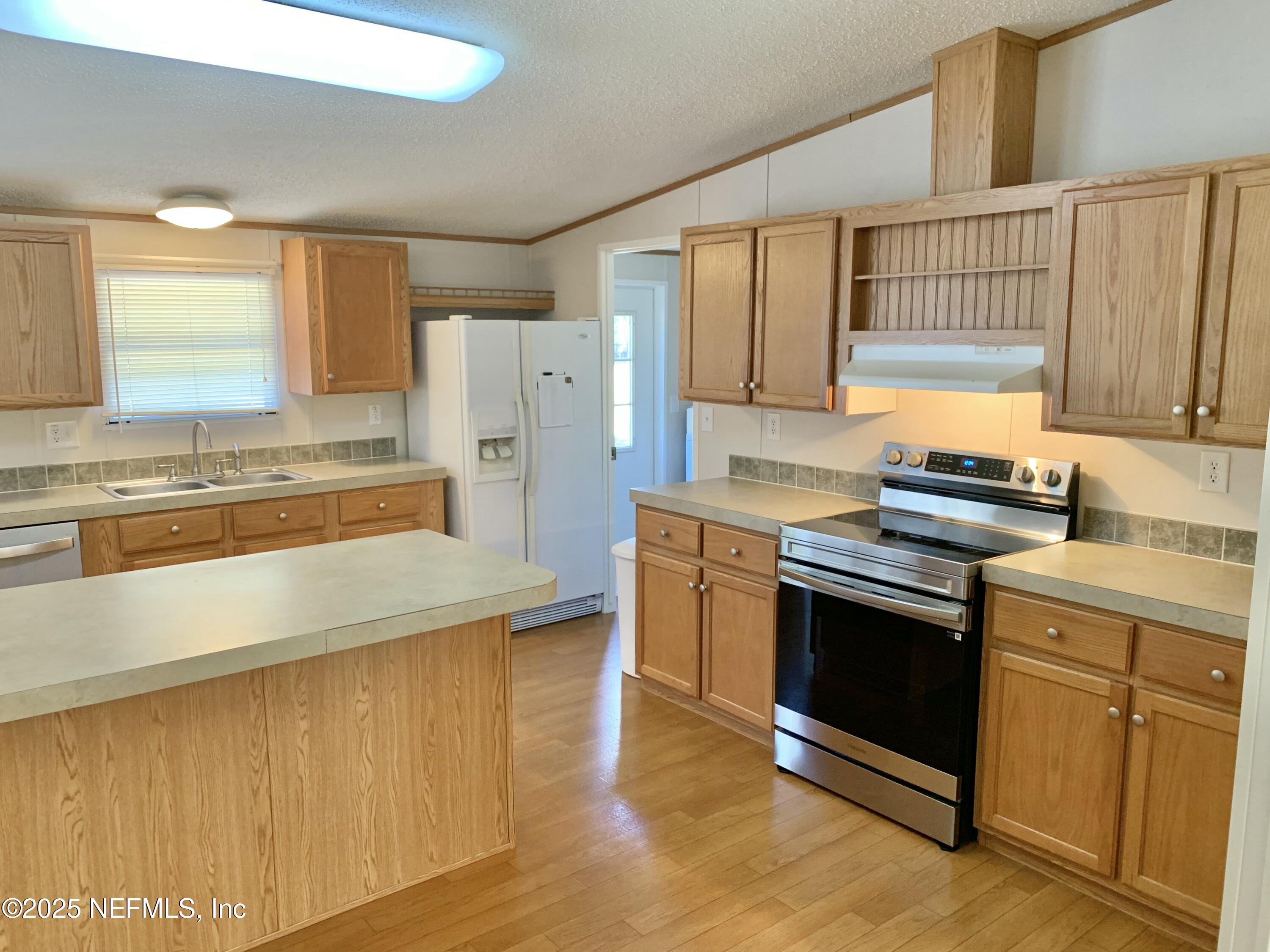 12752 Southeast 9th Place Gainesville, FL 32641 - Photo 13 of 53 a kitchen with stainless steel appliances granite countertop a stove a sink and a refrigerator