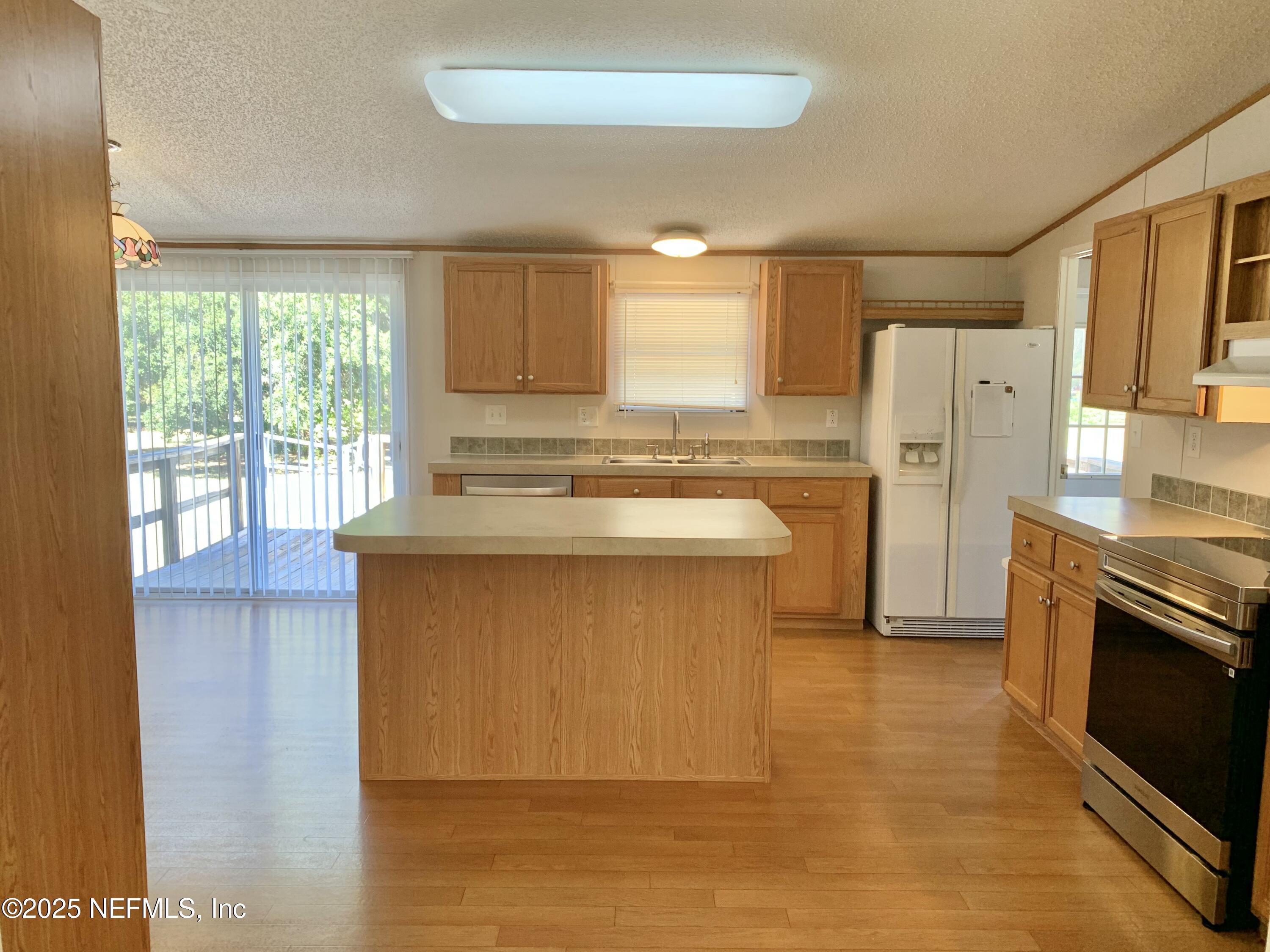 12752 Southeast 9th Place Gainesville, FL 32641 - Photo 6 of 53 a kitchen with stainless steel appliances granite countertop a stove a sink dishwasher a refrigerator and a microwave oven with wooden floor