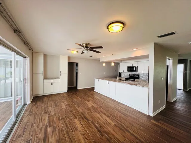 a view of a kitchen with wooden floor and a kitchen