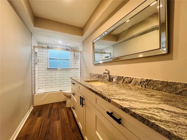 a bathroom with a granite countertop sink and a mirror