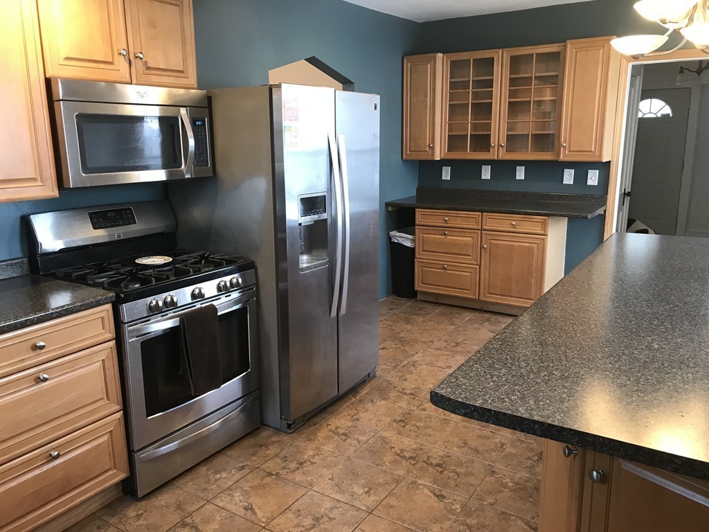 15 Strong Street Springfield, MA 01104 - Photo 4 of 28 a kitchen with stainless steel appliances granite countertop a stove a microwave and a refrigerator