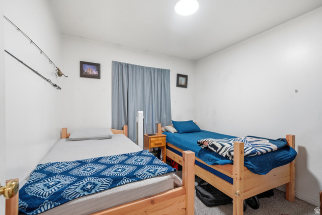 203 North Geneva Road, Unit 10 Provo, UT 84601 - Photo 13 of 30 Bedroom featuring a window with blue drapes, white walls, and a ceiling-mounted light fixture