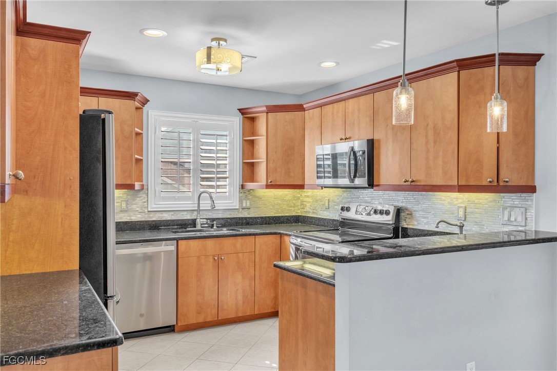 1526 Trafalgar Lane, Unit B Naples, FL 34116 - Photo 19 of 33 a kitchen with stainless steel appliances granite countertop a sink a stove and a refrigerator