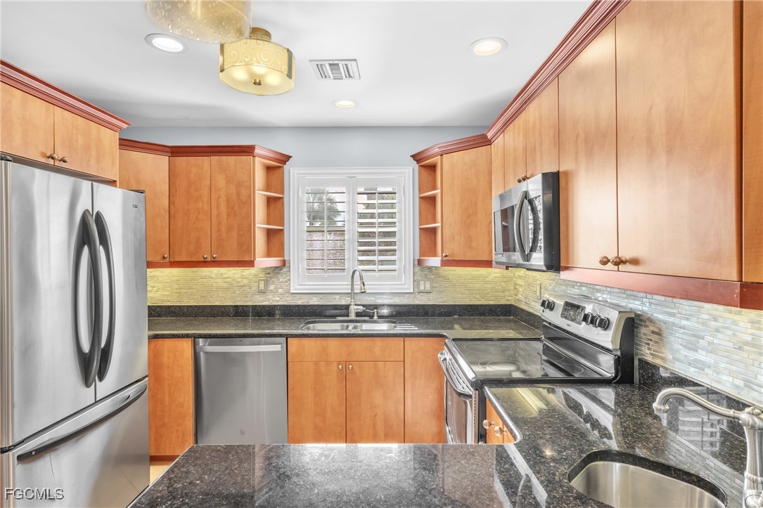1526 Trafalgar Lane, Unit B Naples, FL 34116 - Photo 21 of 33 a kitchen with stainless steel appliances granite countertop a sink and a refrigerator