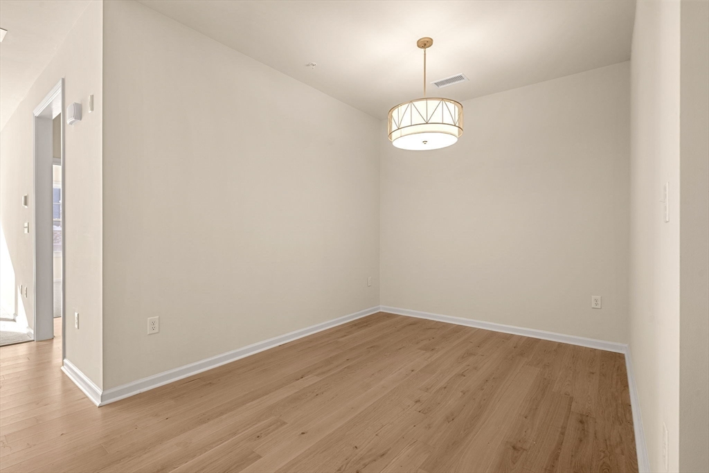 2 Stratton Drive, Unit 102 Woburn, MA 01801 - Photo 13 of 32 an empty room with wooden floor and ceiling fan