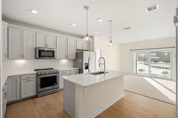 a kitchen with stainless steel appliances granite countertop a stove a sink and a microwave
