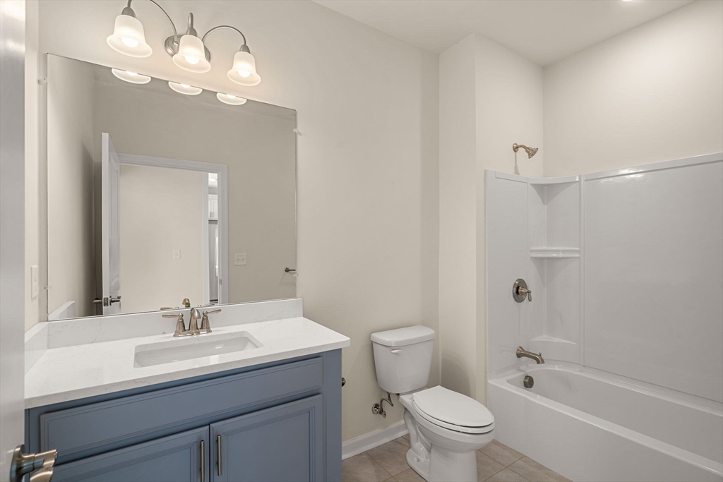 2 Stratton Drive, Unit 102 Woburn, MA 01801 - Photo 21 of 32 a bathroom with a sink a toilet and a mirror