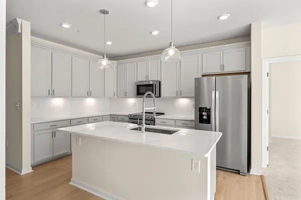 a kitchen with kitchen island a sink stainless steel appliances and cabinets