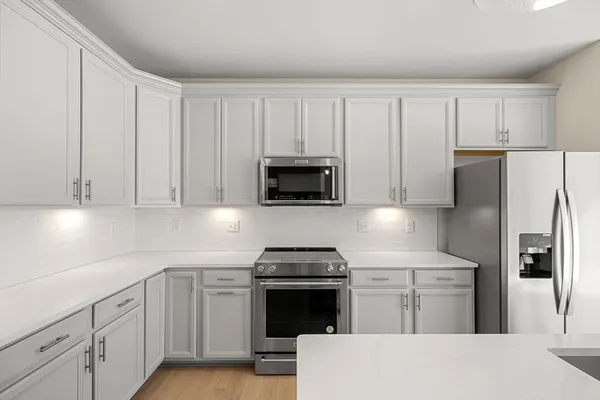 a kitchen with white cabinets and stainless steel appliances