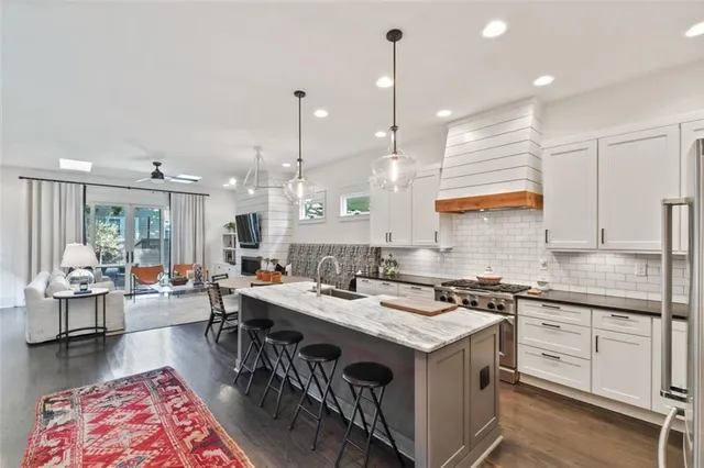 a kitchen with stainless steel appliances granite countertop a sink a stove and a refrigerator