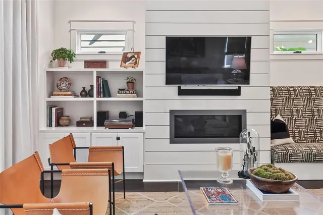 a kitchen with stainless steel appliances kitchen island granite countertop a sink dishwasher a stove a refrigerator and white cabinets with wooden floor