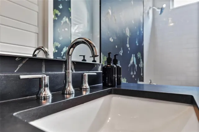 a kitchen with stainless steel appliances granite countertop a sink a stove a refrigerator a center island and a wooden floor