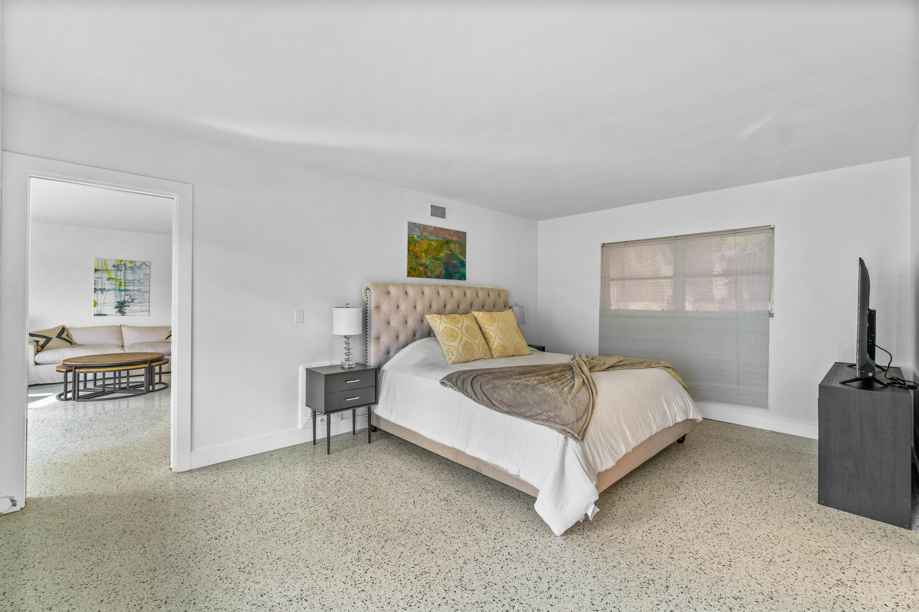 1191 South Ocean Boulevard, Unit 6 Delray Beach, FL 33483 - Photo 13 of 19 a spacious bedroom with a bed and a flat screen tv