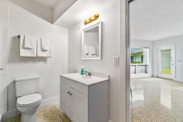a bathroom with a toilet sink and mirror