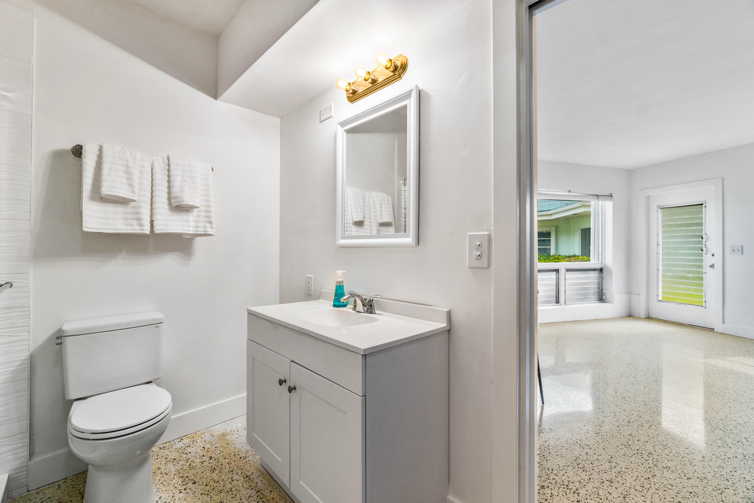 1191 South Ocean Boulevard, Unit 6 Delray Beach, FL 33483 - Photo 16 of 19 a bathroom with a toilet sink and mirror