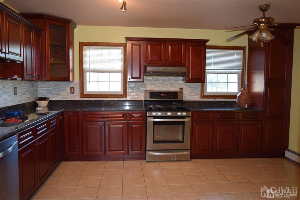 11 Post Boulevard Carteret, NJ 07008 - Photo 9 of 23 a kitchen with stainless steel appliances granite countertop a stove a sink and a microwave